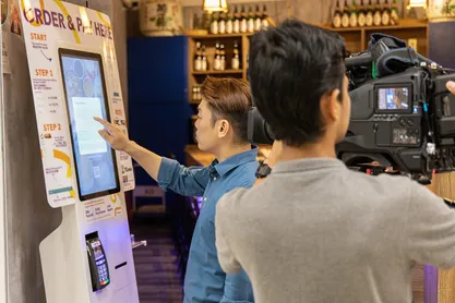 A YQueue kiosk being filmed and tested inside a restaurant