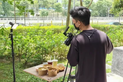 A mobile ordering experience being filmed outdoors beside a meal